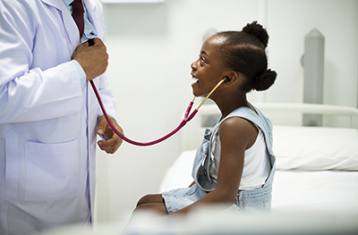 Friendly pediatrician entertaining his patient